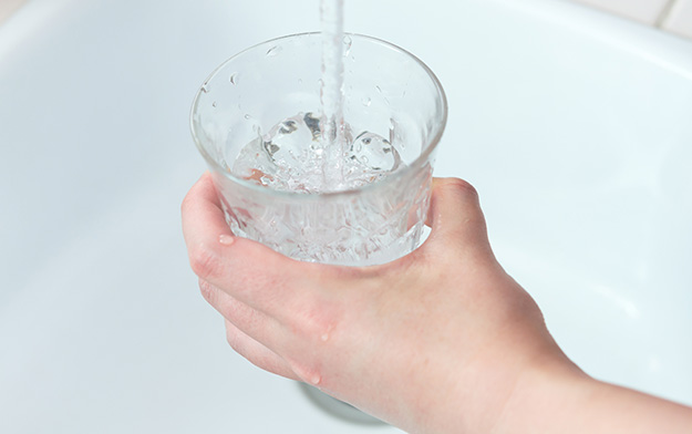 コップに水を注いでいる画像
